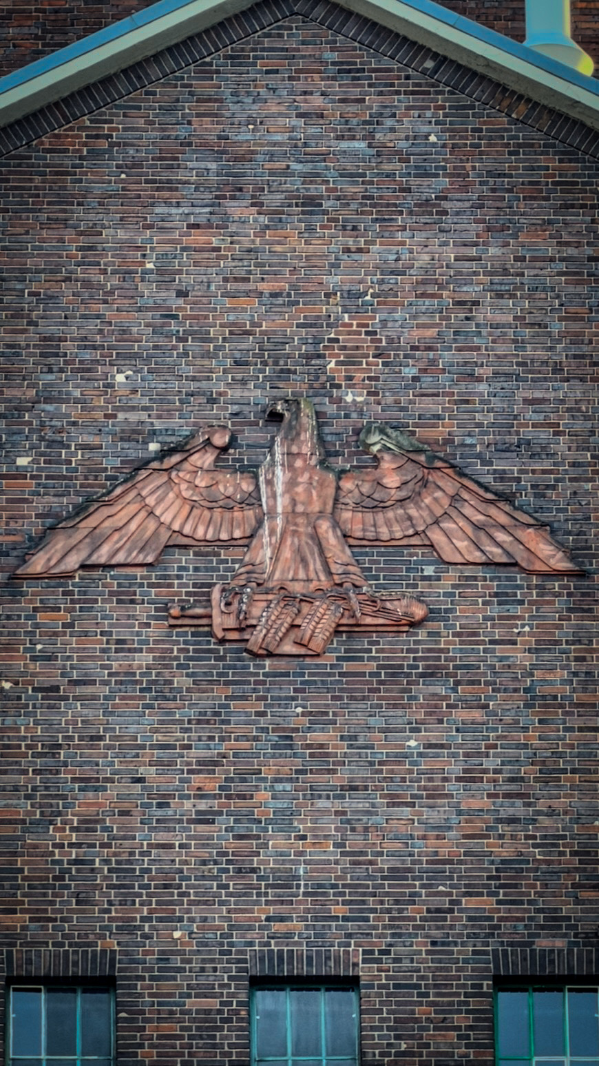 Large eagle sculpture mounted on a brick wall